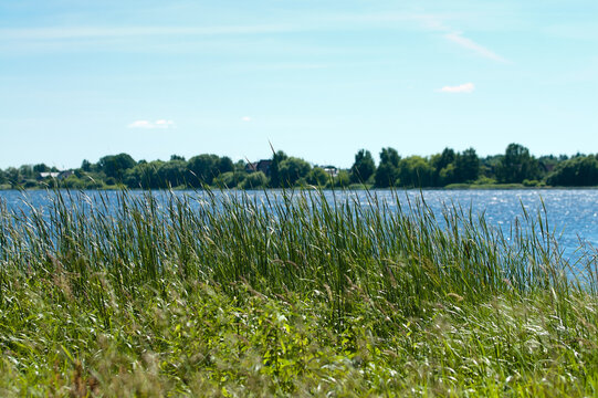 A summer landscape featuring a river with its banks and a blue sky