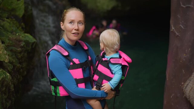 Mother and toddler at cenote cave entrance in Mexico.