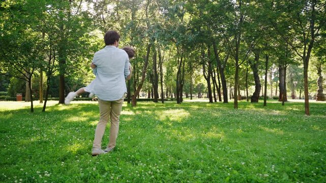 Happy father playfully catches energetic child during fun game