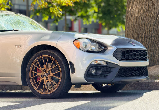 Exterior of Fiat 124 Spider I convertible silver color. Fiat Abarth 124 Spider on parking lot silver color. Italian sport car. 