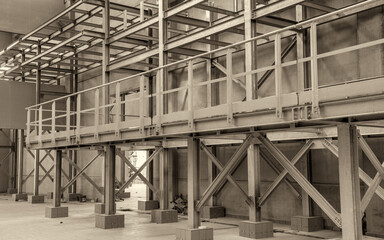 Obraz premium Large unfinished industrial space featuring metal beam framework and raw warehouse construction interior details