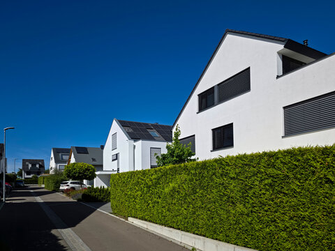 germany, beautiful modern neighborhood in ostfildern kemnat showcasing photovoltaic roofs surrounded by lush greenery beneath radiant summer blue sky