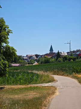 germany, scenic country road leading toward ostfildern kemnat surrounded by colorful summer fields beneath vibrant deep blue sky
