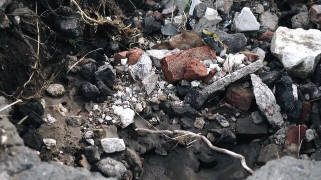 Broken bricks, stones and other construction debris are piled together. Close-up shooting