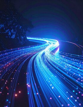 Dynamic blue fiber optic light trails flow like a digital highway around a dark cliff at night, symbolizing fast data connection and futuristic technology. No people.