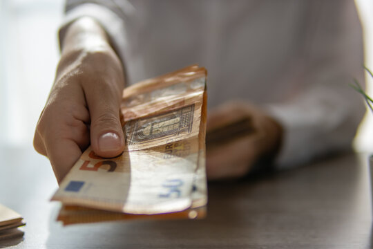 Hand offering or receiving a stack of 50 euro banknotes, illustrating concepts of finance, payment, transaction, investment, wealth, and saving money in business