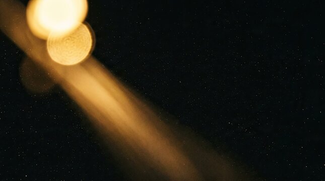 Golden light bokeh effect on black background with stars