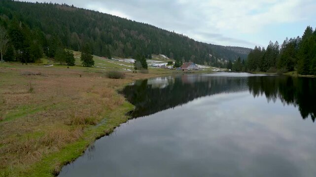 Survol des eaux calmes du lac de la T&eacute;nine dans les Vosges - Vall&eacute;e de Chajoux en hiver