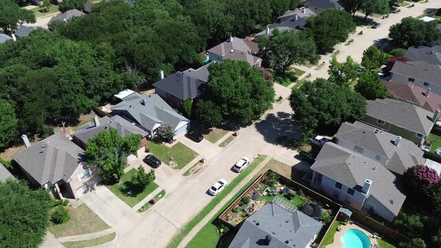 Fenced residential lots feature private yards with sparkling blue pools. Sharp roof pitches meet dense perimeter woodland, capturing desirable suburban lifestyle features in Flower Mound, Texas