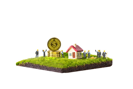 miniature couple and miniature house with red roof on green grass isolated on white background.