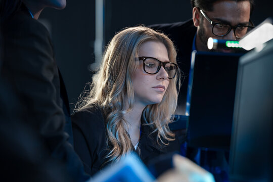 Night watch cybersecurity team collaborates intensely Diverse analysts monitor multiple screens tracking active threats protecting critical infrastructure vital digital defense activated now.