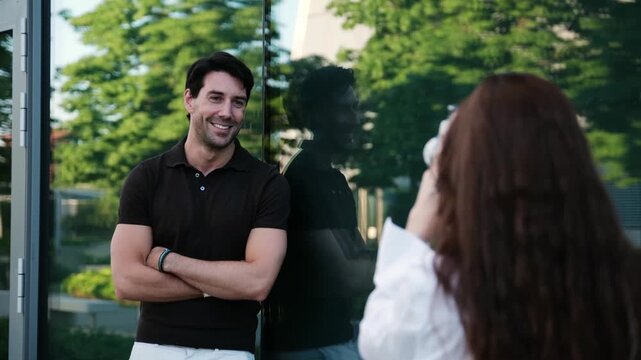 Young woman taking photos of a smiling male model with a vintage film camera