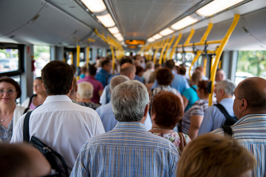 Crowded bus with many people standing inside