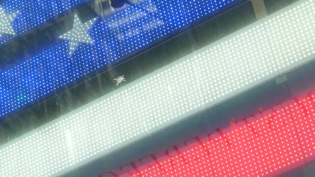 American flag on Broadway, Times Square in New York City, United States. Electric lights glowing. Symbol of democracy, national attribute of USA. 4th July or 911 September 11 concept. Military Island.