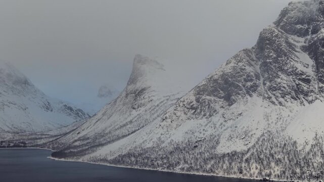 Monta&ntilde;as nevadas en fiordos noruegos nevando