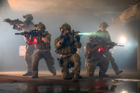 Highly trained suicide squad team in full tactical military uniform and heavily armed with weapons conducting a foot patrol mission inside a ruined abandoned building