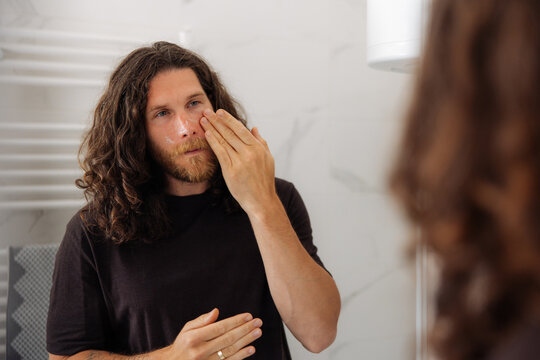 Bearded Man Applying Skincare 
