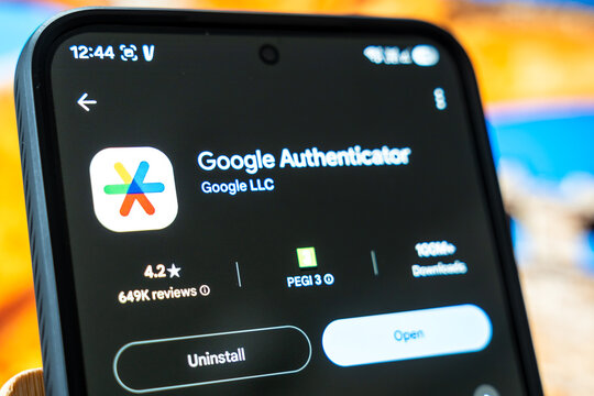 Warsaw, Poland - July 6, 2026: Close-up of a smartphone screen displaying Google Authenticator application with app ratings and download statistics during a tech demonstration on a colorful backgroun