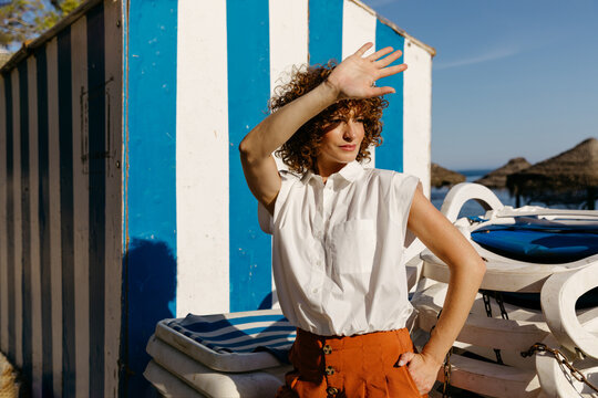 Woman shielding eyes from sun on beach