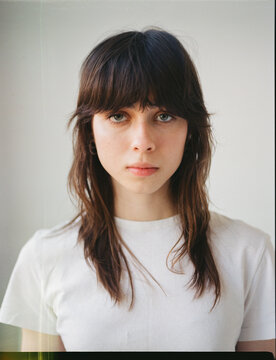 Model poses for a close-up at indoor studio with simple background