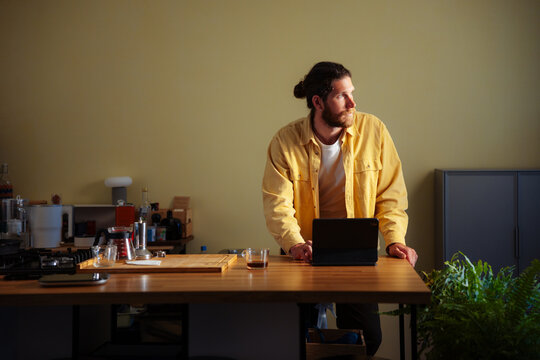 Man Working Remotely In Kitchen With Tablet