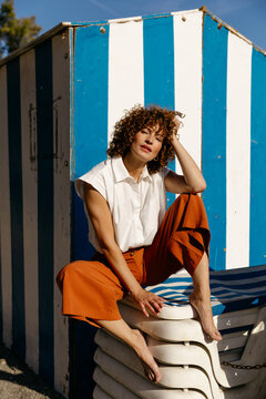 Woman near beach cabin in sunlight