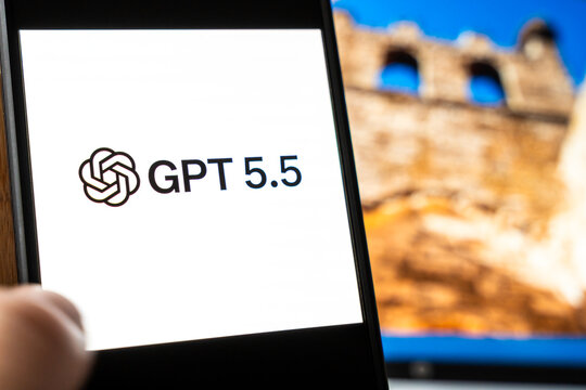 Warsaw, Poland - July 6, 2026: Person holding smartphone displaying GPT 5.5 interface featuring AI concept on screen with blurred ancient wall background