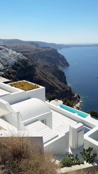 White architecture in Santorini island, Greece. Blue sea and the blue sky at sunny day. Luxury resort. Travel and summer vacation concept. Vertical video
