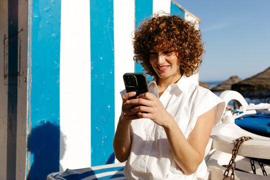 Woman texting outdoors smiling