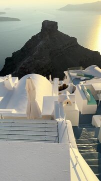 Beautiful sunset in Santorini island, Greece. White architecture with sea view. Blue sea and the blue sky at sunset. Summer travel and vacation. Vertical video
