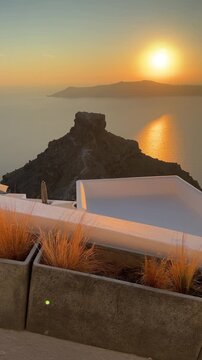 Beautiful sunset in Santorini island, Greece. White architecture with sea view. Blue sea and the blue sky at sunset. Summer travel and vacation. Vertical video
