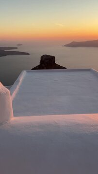 Beautiful sunset in Santorini island, Greece. White architecture with sea view. Blue sea and the blue sky at sunset. Summer travel and vacation. Vertical video
