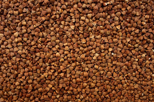 Buckwheat pattern top view. Roasted kernel texture. Brown agricultural background. Whole grain wallpaper. Raw cereal crop. Dietary food backdrop. Triangle seed close up. Natural groats surface. Health