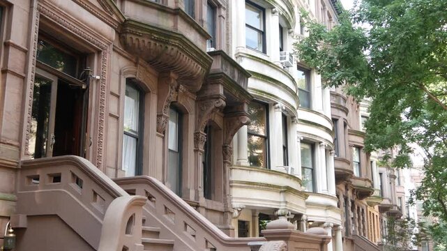 New York City townhouse buildings, brownstone row houses in Manhattan or Brooklyn, United States of America. Classic buildings on residential district street. Real estate property. Rowhouse townhome.