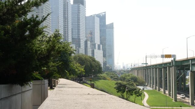 New York City Riverside Park South, Manhattan, United States. Modern residential buildings in Upper West Side. Urban skyscraper skyline, luxury apartments, condos. Summer green grass lawn, riverfront.