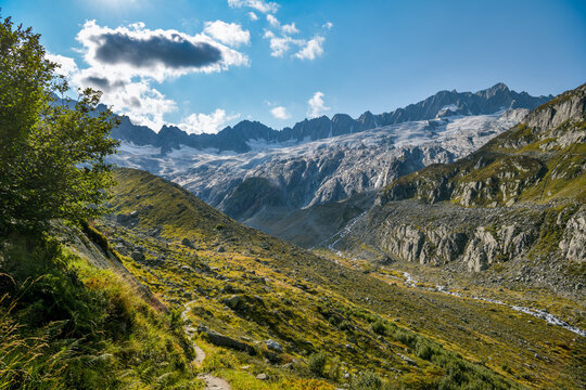 Trail through a rugged glacial valley with a stream