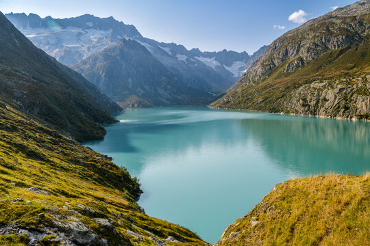 Turquoise mountain lake below a glacier valley