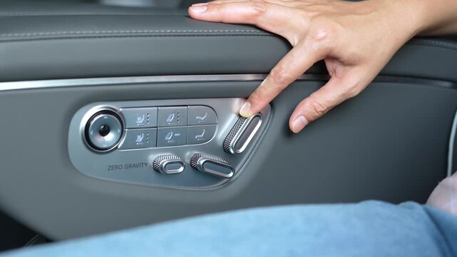 Adjusting the premium leather car passenger seat using the automatic electronic adjustment switch panel.