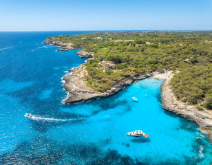 Aerial view of sea in Mallorca, Spain. Luxury yachts, boat anchored in turquoise water cove, rocky coast with green pine trees, sandy beach on sunny summer day. Mediterranean drone landscape. Vacation © den-belitsky