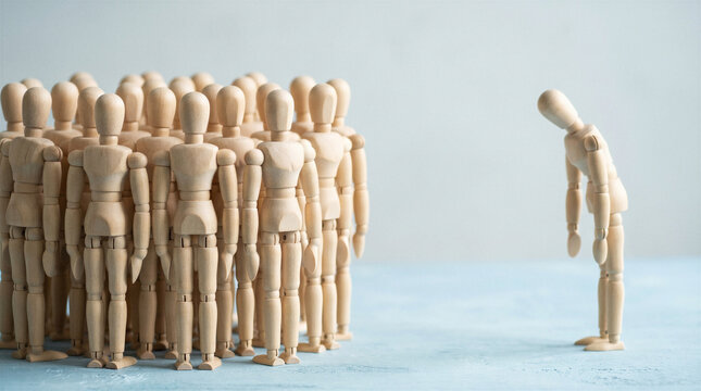 Wooden mannequin bowing before group of figures for apology, social pressure and exclusion concept.