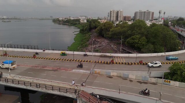 Aerial Drone View of Bridge Over River in Surat with Urban Skyline, Traffic, Riverside Development and Monsoon Landscape, Gujarat India