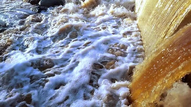 Waterfall of foamy water coming from sewer or river or a water treatment plant