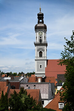 Church clock tower with onion dome above red tiled roofs