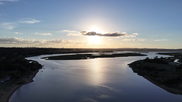 Drone aerial view of winding waterways and coastal wetlands at sunset near Punta del Este, Uruguay, featuring calm reflections, golden light and a peaceful natural landscape.