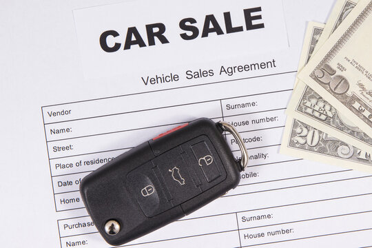 Car key, dollar banknotes and vehicle sales agreement. Inscription car sale. Sales, purchases of automobile. Transportation