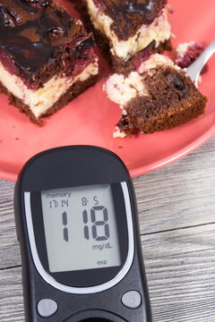 Glucometer with result of sugar level and cheesecake with cherries and chocolate. Healthy lifestyle and nutrition during diabetes