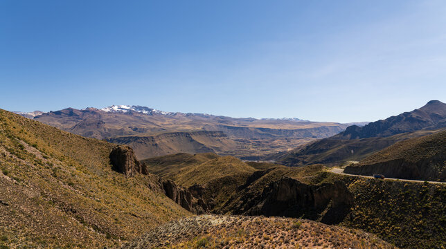A cargo truck drives along a winding mountain highway carved into the rugged canyons and valleys of the high Andes range in Arequipa, Peru