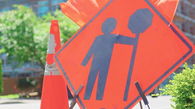 Langford, BC, Canada &ndash; July 6, 2026: Traffic control person sign with BC Transit bus background