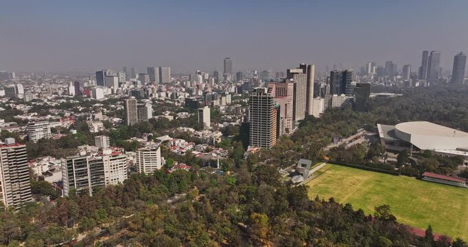 Mexico City Aerial v78 panning shot around polanco neighborhood capturing urban cityscape, national auditorium and bosque de chapultepec park on a hazy day - Shot with Mavic 3 Cine - January 2022