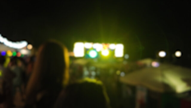Silhouettes of concert crowd with stage lights, out of focus blurred photo